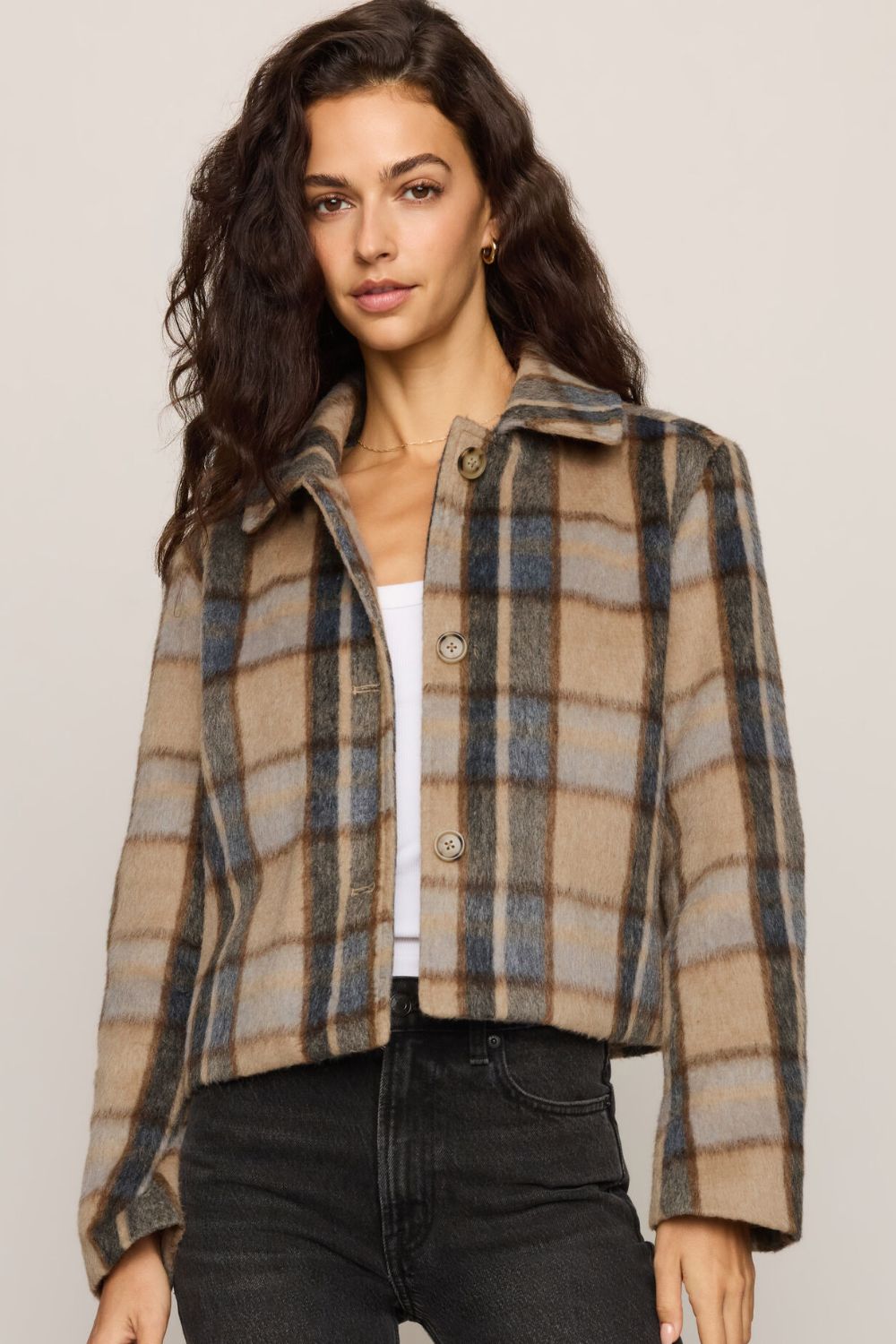 Woman modeling a plaid jacket on a plain white background