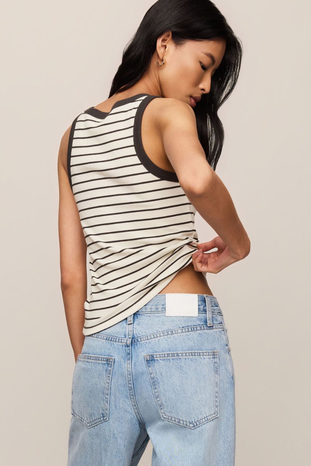 woman wearing a striped tank top on a white background