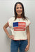 Woman wearing a sweater with an American flag design against a plain background