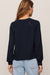 woman wearing navy sweater on a white background