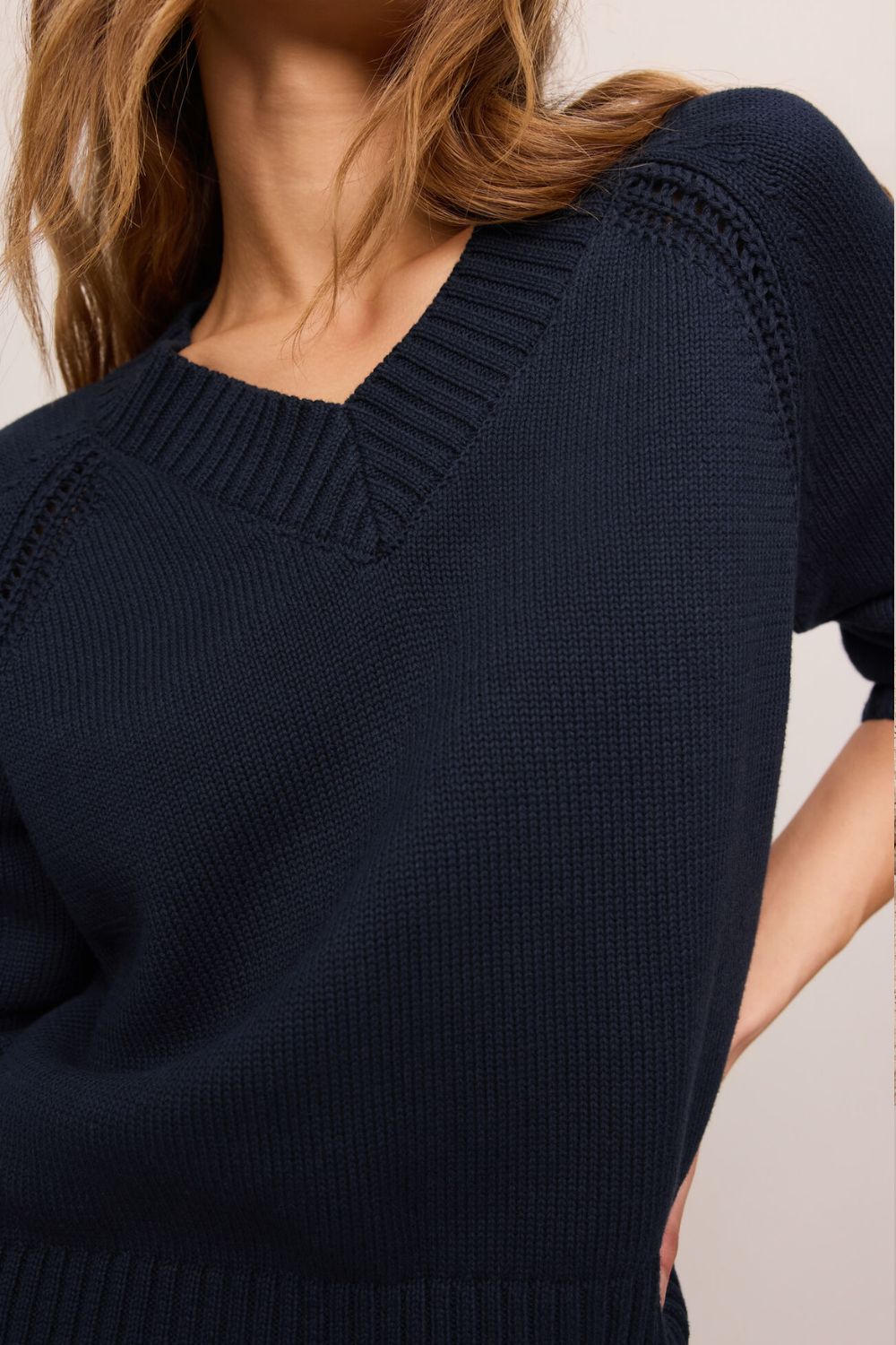 woman wearing navy sweater on a white background