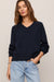 woman wearing navy sweater on a white background