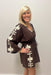 Woman wearing brown with cream detail dress against white background