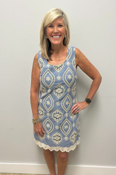 Woman wearing light blue dress with lace embroidered detail in cream