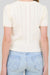 Person wearing a white textured top and light blue jeans on a plain background