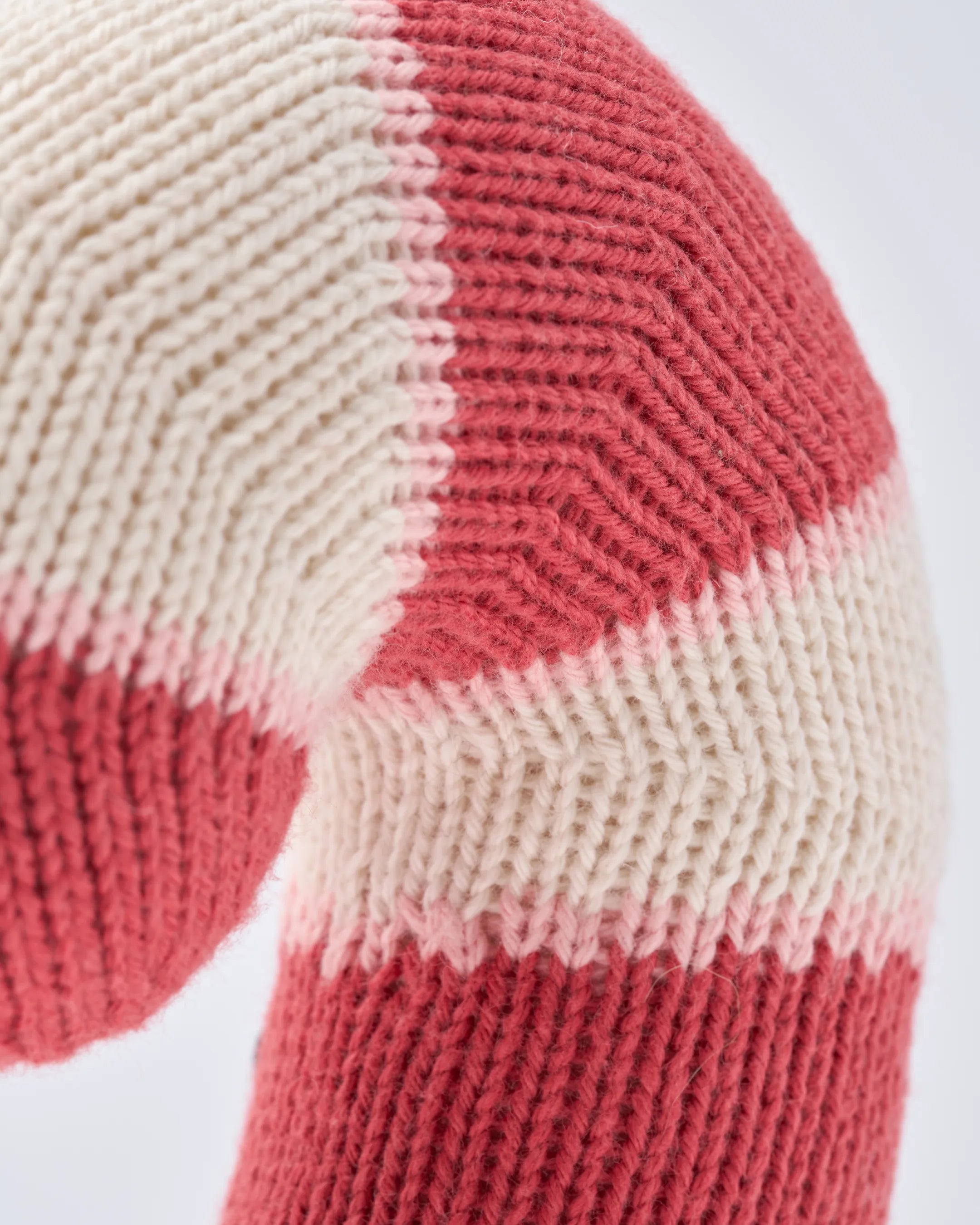 Close-up of the knit blush and white stripes on a candy cane