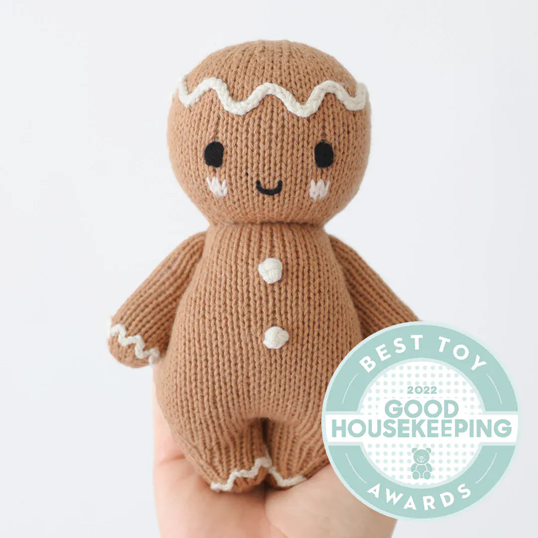 Hand-knit gingerbread held in an open hand to show its small size