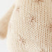 Close-up of the hand-knit stitching on a cream giraffe stuffed animal