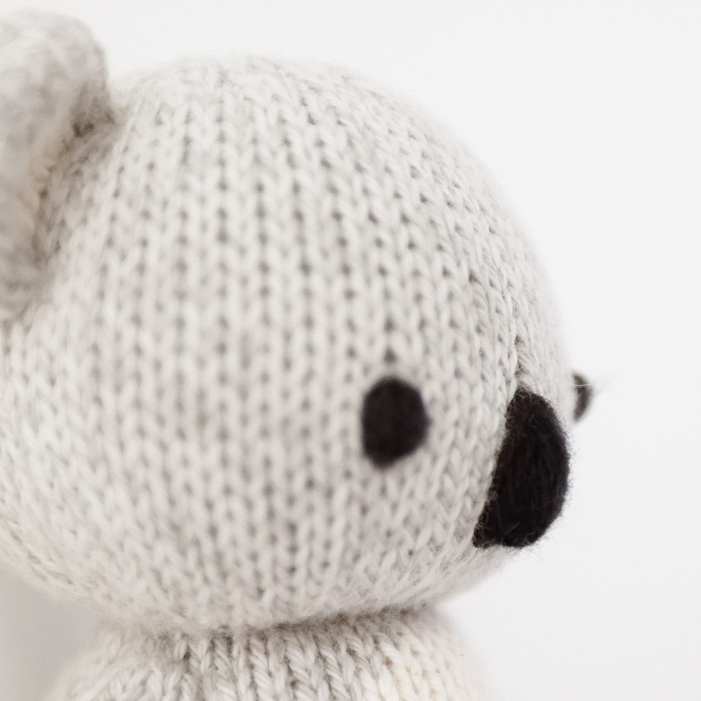 Close-up of the knit ear and nose on a gray koala stuffed animal