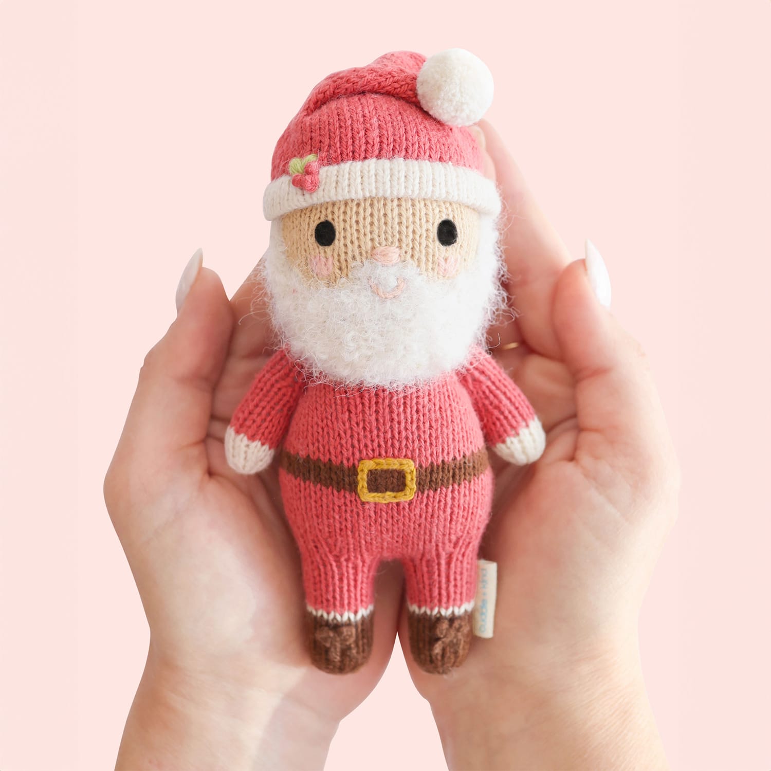 Small hand-knit Santa doll held in two hands
