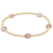 Gold bracelet with pink beads on a white background
