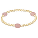 Gold bracelet with pink beads on a white background