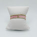 Three stacked bracelets on a white display pillow: pink seed bead bracelet with a gold bead between two gold beaded bracelets