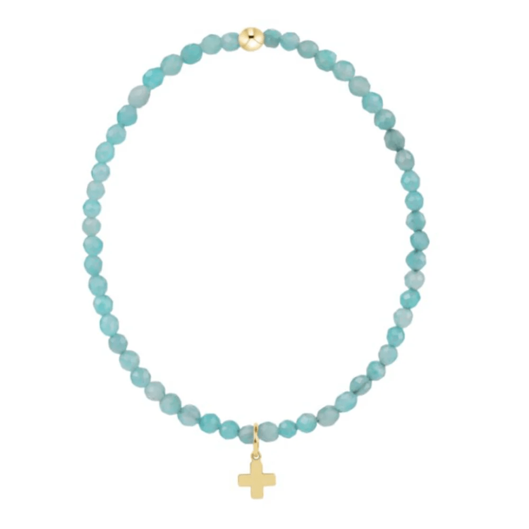 Turquoise beaded necklace with a gold cross pendant on a white background