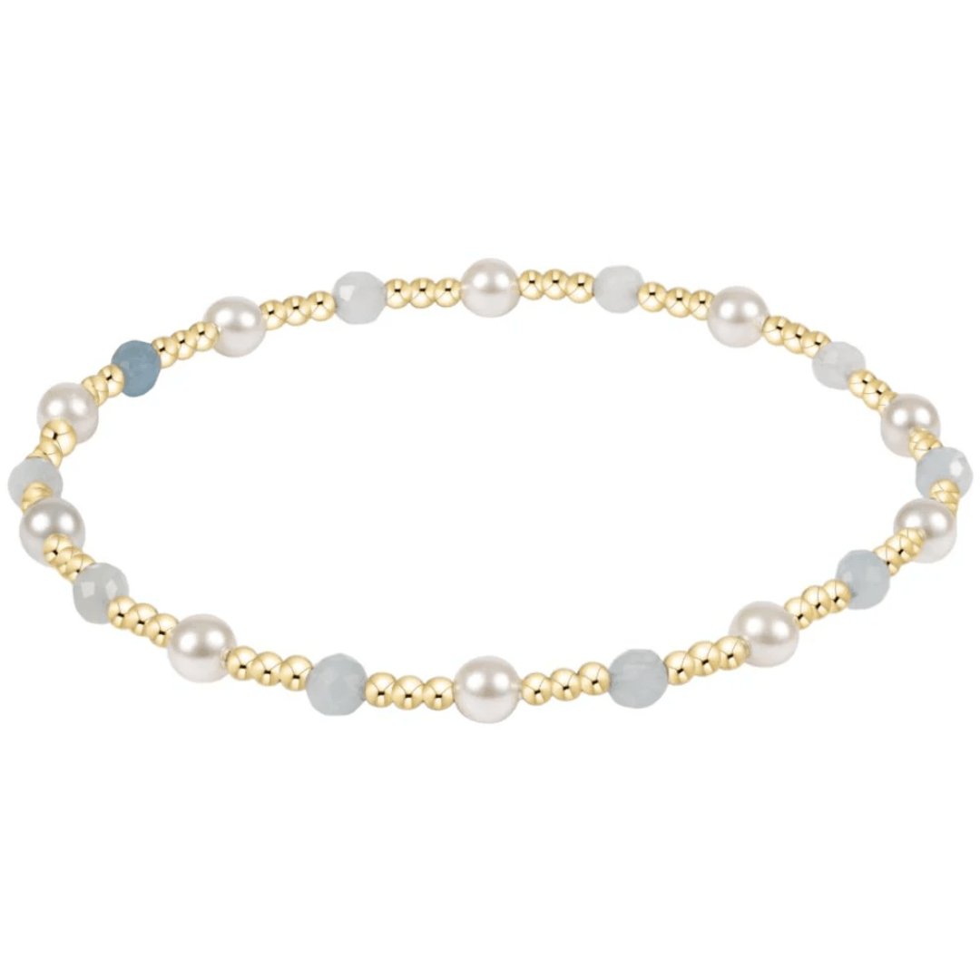 Pearl and gold beaded bracelet on a white background