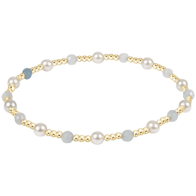 Pearl and gold beaded bracelet on a white background