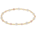 Pearl and gold beaded bracelet on a white background