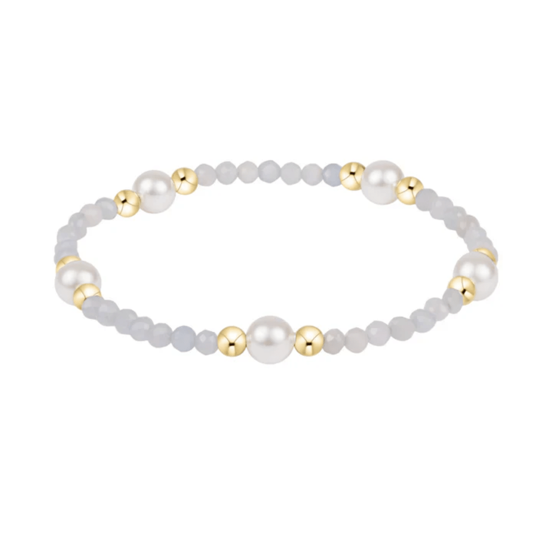 Bracelet with white and gold beads on a white background