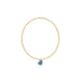 Gold bracelet with a blue gemstone pendant on a white background