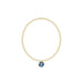 Gold bracelet with a blue gemstone pendant on a white background