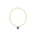 Gold bracelet with a blue gemstone pendant on a white background