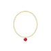 Gold bracelet with a red gemstone on a white background