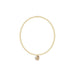 Gold bracelet with a small round pendant on a white background