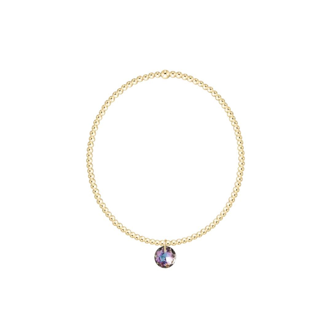 Gold bracelet with a purple gemstone on a white background
