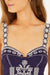 Navy blue top with white floral embroidery on a white background