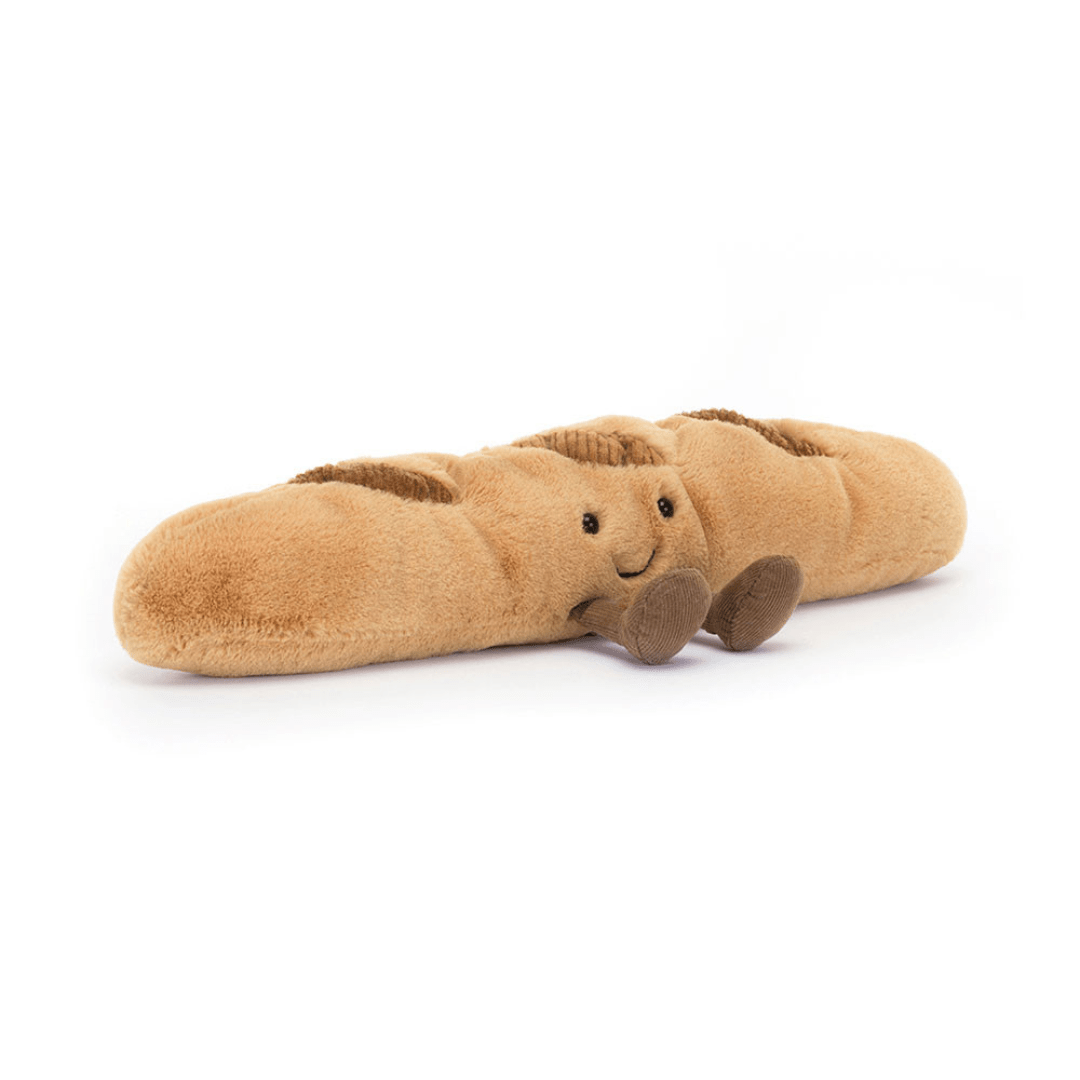 Plush toy shaped like a baguette with a face on a white background