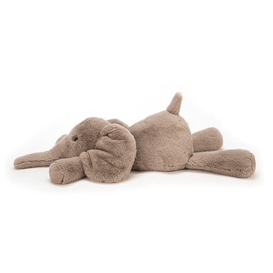 Plush toy elephant and dog lying on a white background