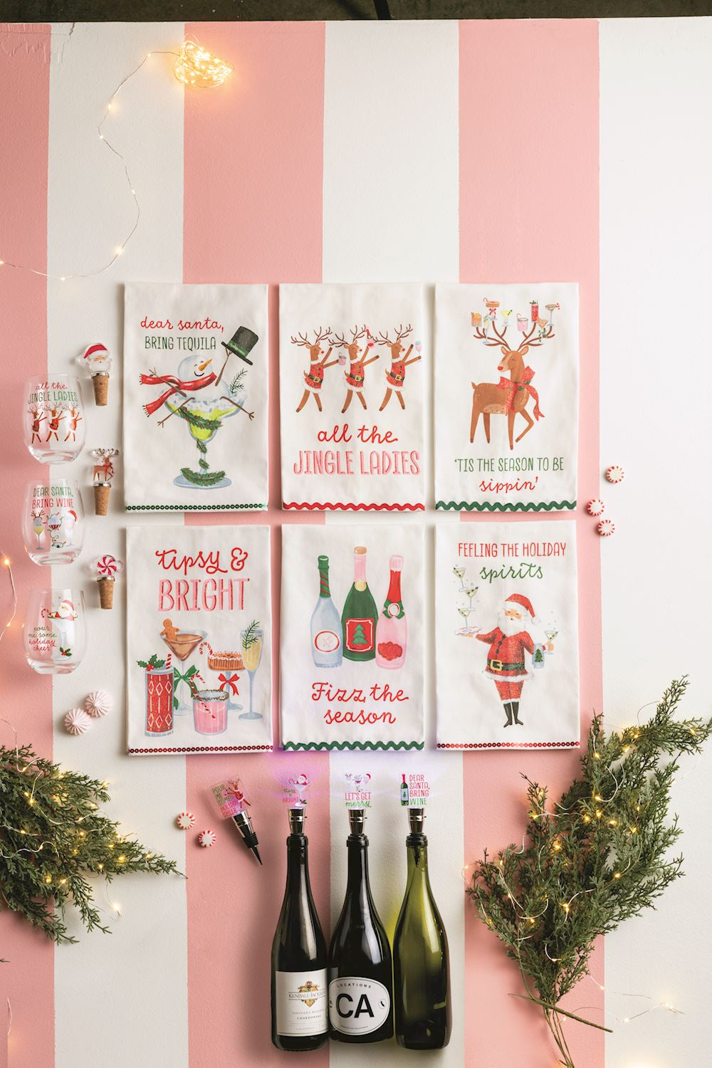 Holiday wine glass and stopper sets on a pink striped background