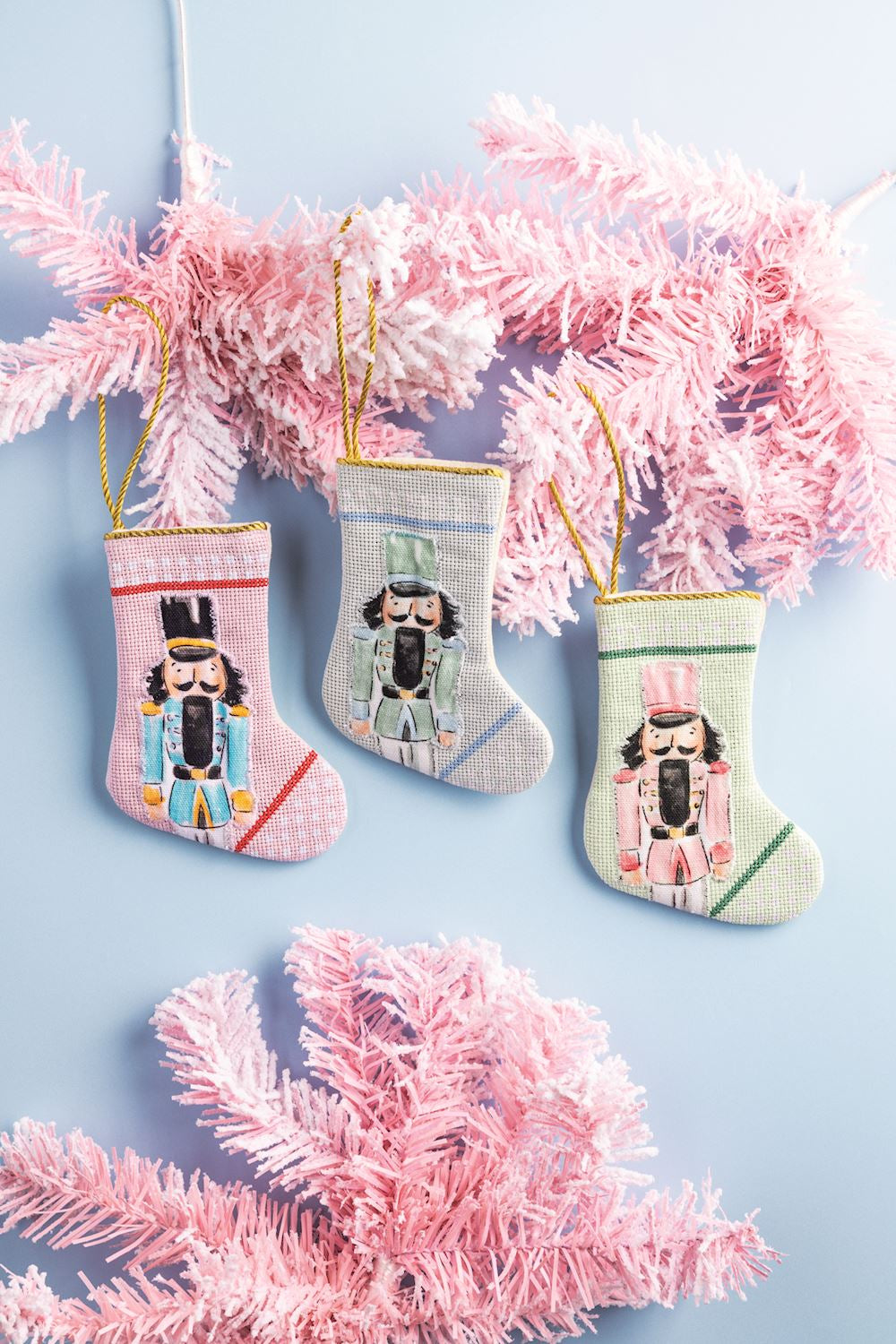 Mini nutcracker stockings with pink tinsel on a blue background