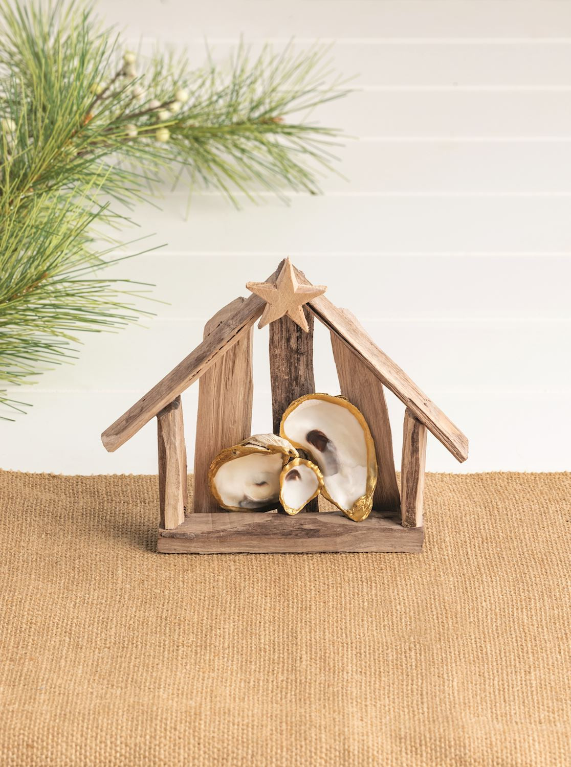 Oyster shell Nativity on a wood table with greenery