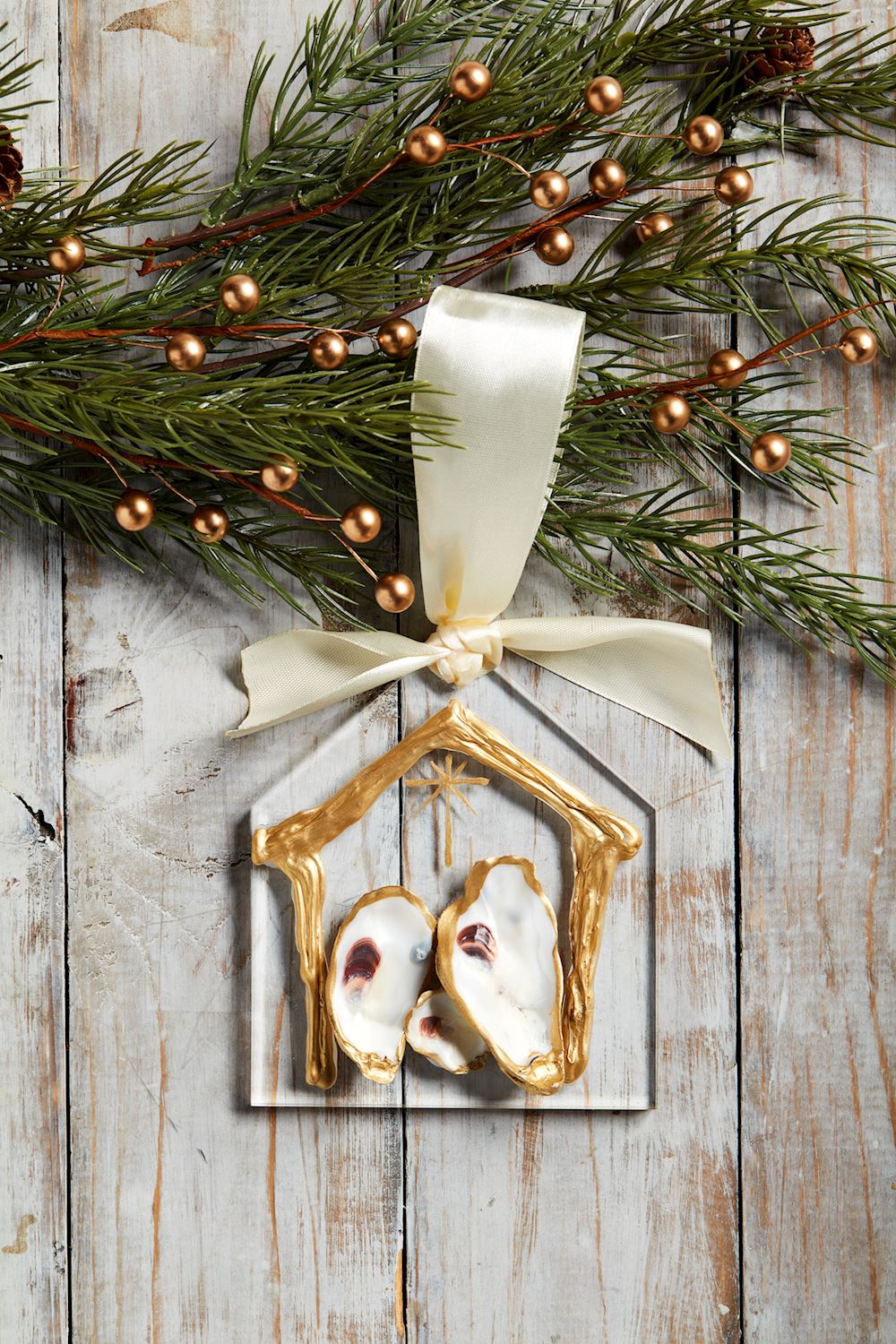 Oyster Nativity ornament hanging with greenery