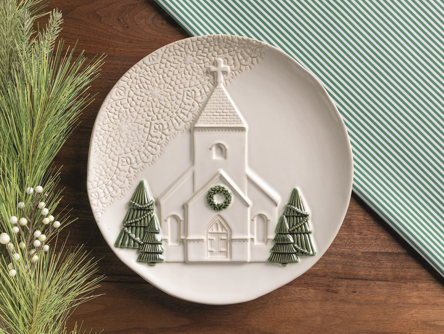 Pressed lace church platter on a table with greenery