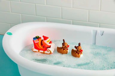 Santa and reindeer duck bath toys floating in a bathtub