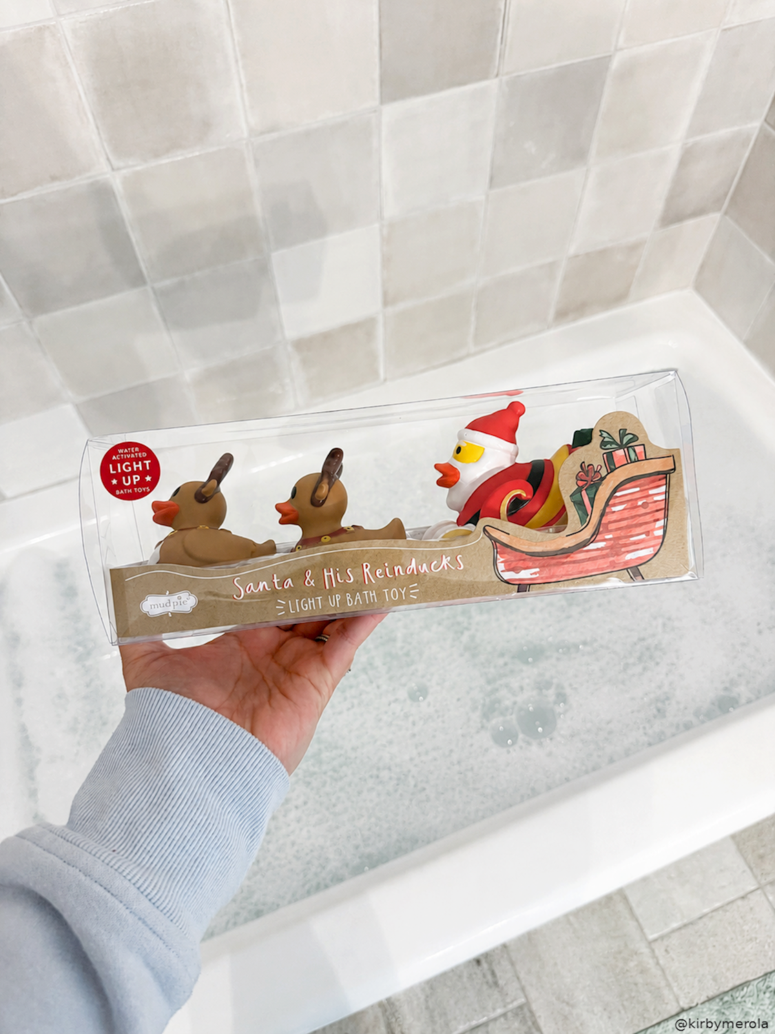 Hand holding the Santa sleigh bath toy