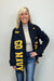 Woman wearing a navy scarf with 'GO NAVY' text, standing against a plain background