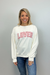 Woman wearing a white sweatshirt with 'LOVER' printed in red on a plain background