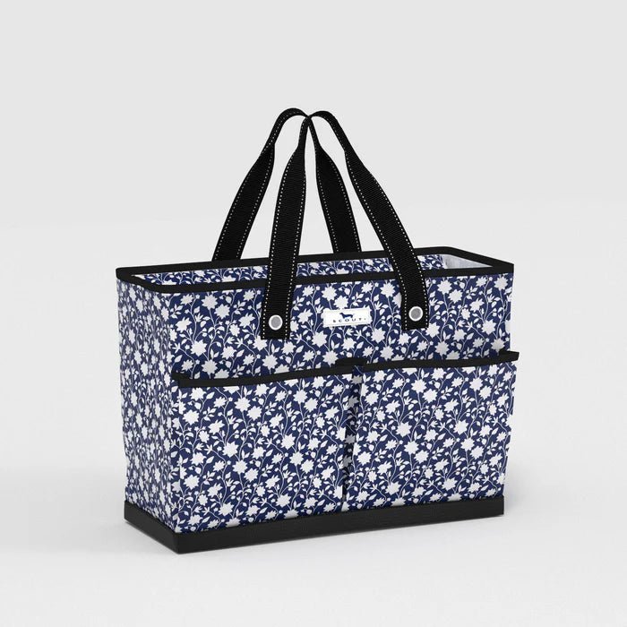 Blue floral tote bag with black handles on a light gray background