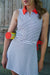 Woman wearing a striped dress with red accents against a wooden background