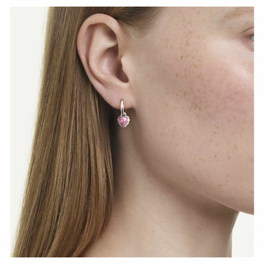 Model wearing the silver Chroma drop earrings with pink heart stones