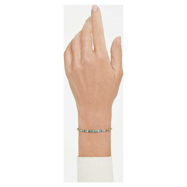 Model wearing the gold Imber bracelet with gradient blue crystals