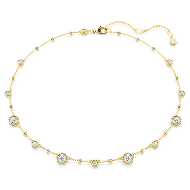 Gold Imber necklace with scattered crystals and metal drops on a white background