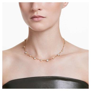 Model wearing the gold Imber necklace with scattered crystals and metal drops