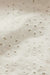 Close-up of a textured white fabric with floral cut-out pattern