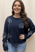 Ava wearing navy sweater with white embroidered seashells and starfish