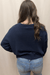Ava wearing navy sweater with white embroidered seashells and starfish